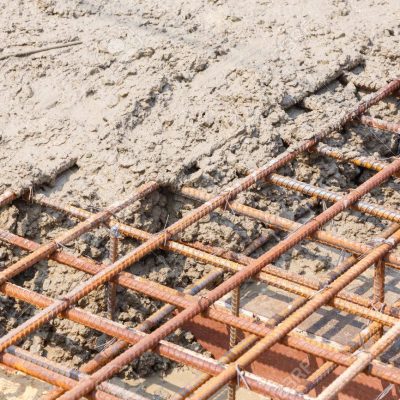 Close up wet cement pour on deformed steel bars with tiewires in construction site, building reinforced concrete floor pouring, rebar reinforcement